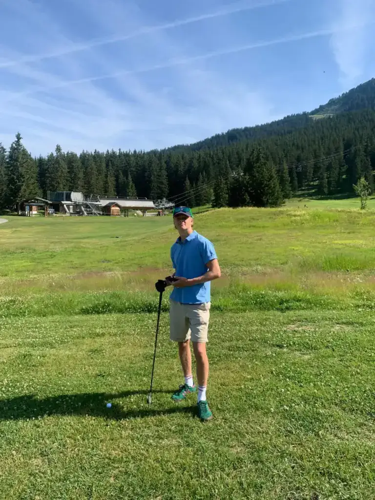 Golfer enjoying the scenic alpine golf course in Méribel during a summer holiday at La Petite Cachée in Les Trois Vallées, France.