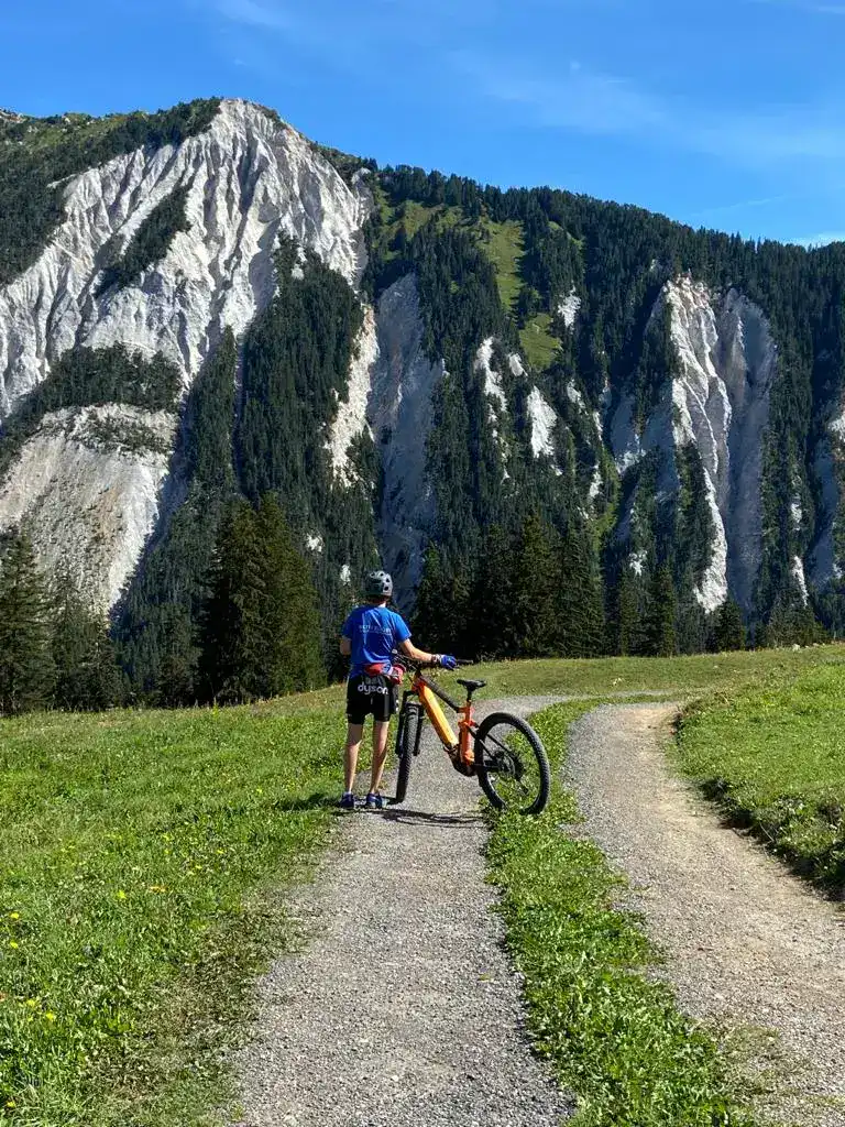 Cyclist enjoying a mountain biking trail near Méribel during a summer holiday at La Petite Cachée in Les Trois Vallées, France.